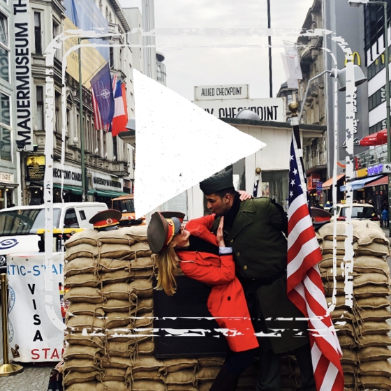 A woman and a man embrace the Cold War at Checkpoint Charlie in Berlin, Germany.