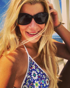 A blonde woman smiles on the beach in a bikini in Palma de Mallorca.